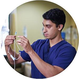 Photo of a nursing student priming an IV line